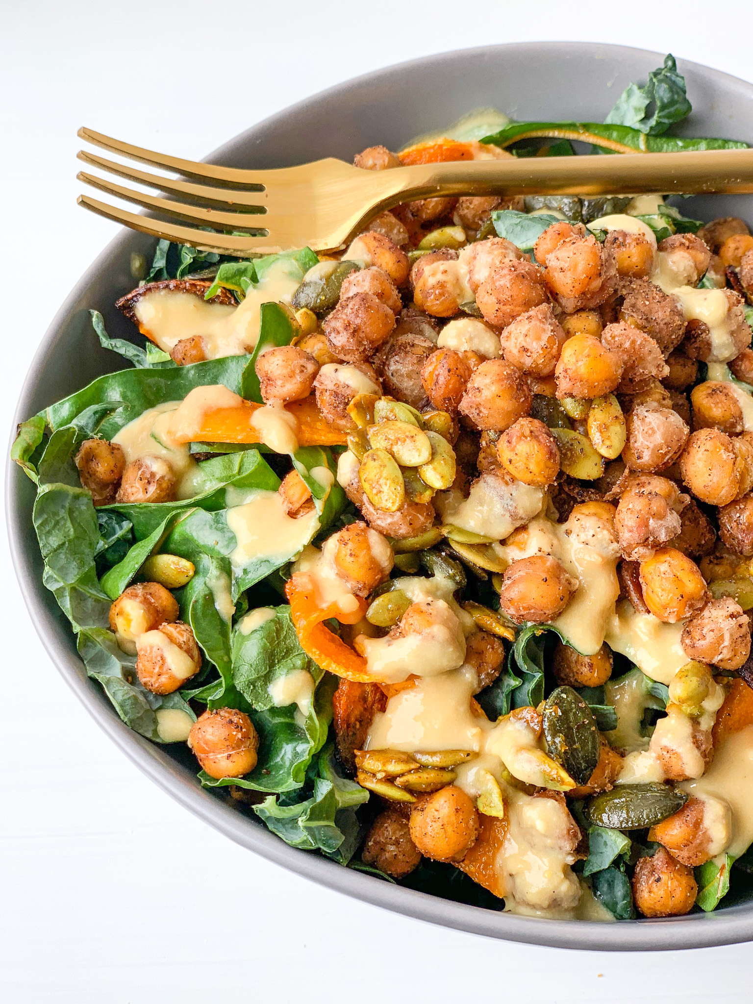 Easy ‘cheezy’ hummus sauce in a bowl with chic peas and spinach