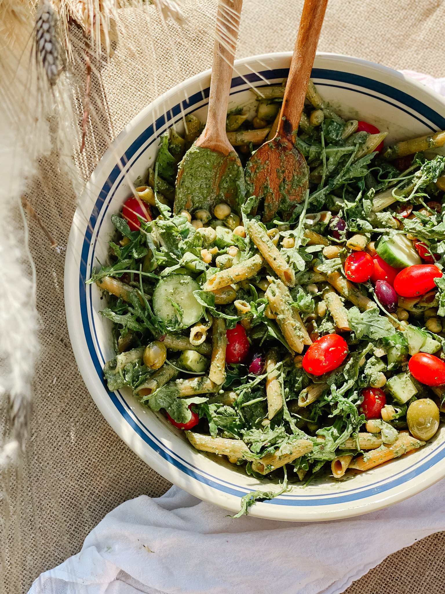 Vegan pesto on pasta in a bowl with tomatoes and other topings